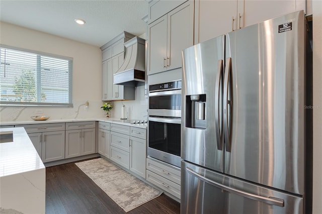 14007 Creek Harbor Dr, Orlando, FL 32824 - kitchen featuring gray cabinetry, custom range hood, dark wood-style floors, appliances with stainless steel finishes, and decorative backsplash