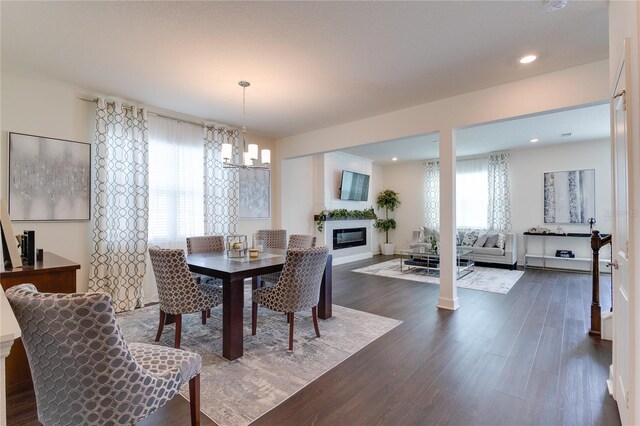 14007 Creek Harbor Dr, Orlando, FL 32824 - dining area with dark wood-style floors, a glass covered fireplace, recessed lighting, and an inviting chandelier