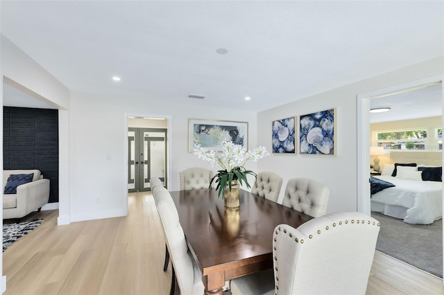 dining space with light hardwood / wood-style flooring and french doors