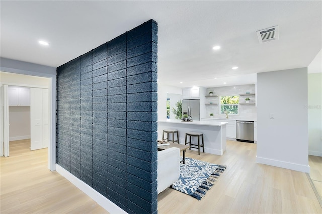 hallway with light hardwood / wood-style floors