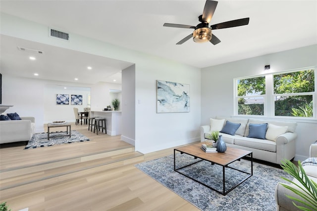 living room featuring light wood-type flooring and ceiling fan