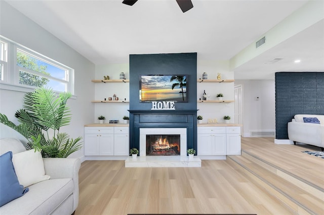 living room featuring light hardwood / wood-style flooring and ceiling fan