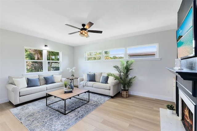 living room with ceiling fan and light hardwood / wood-style flooring