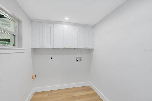 laundry area featuring washer hookup, light hardwood / wood-style flooring, cabinets, and hookup for an electric dryer