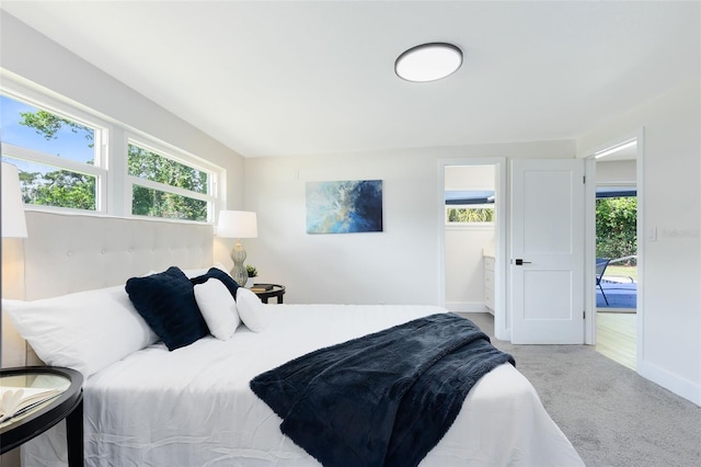 bedroom featuring light carpet, multiple windows, and access to outside