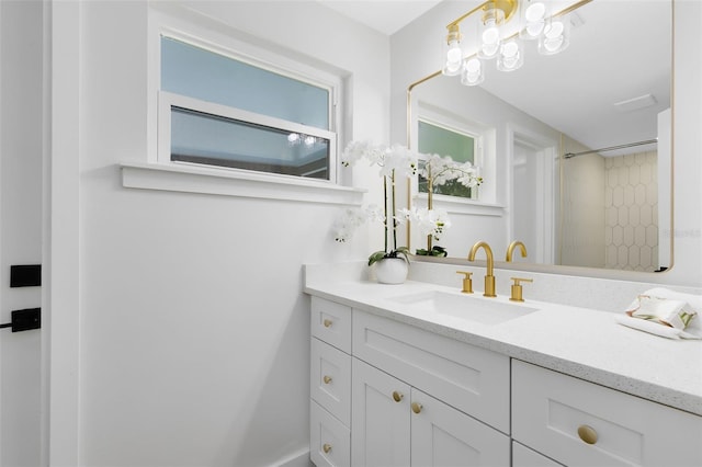 bathroom with a tile shower and vanity