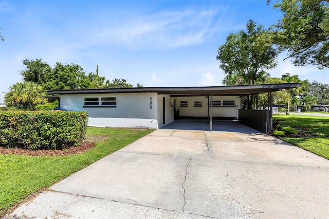 ranch-style home featuring a front lawn and a carport