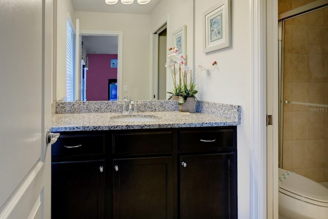 bathroom with toilet, a stall shower, and vanity