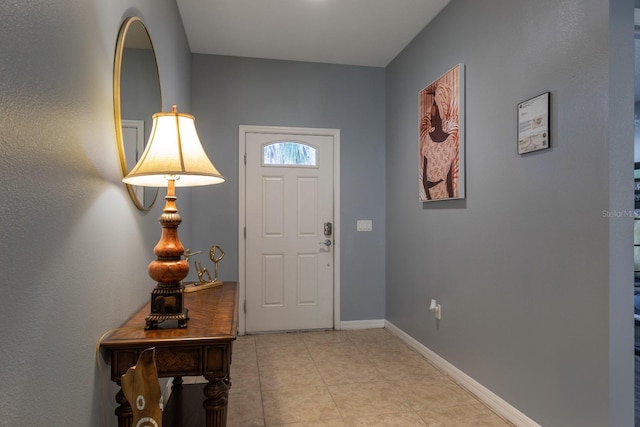 entryway with light tile patterned floors and baseboards