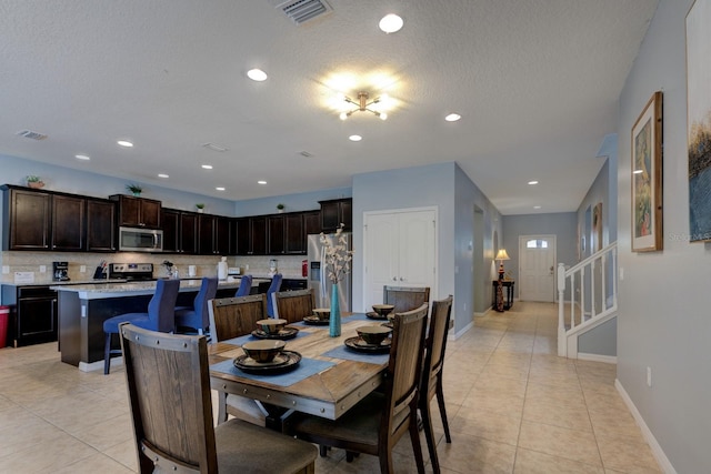 dining room with a textured ceiling and light tile patterned flooring