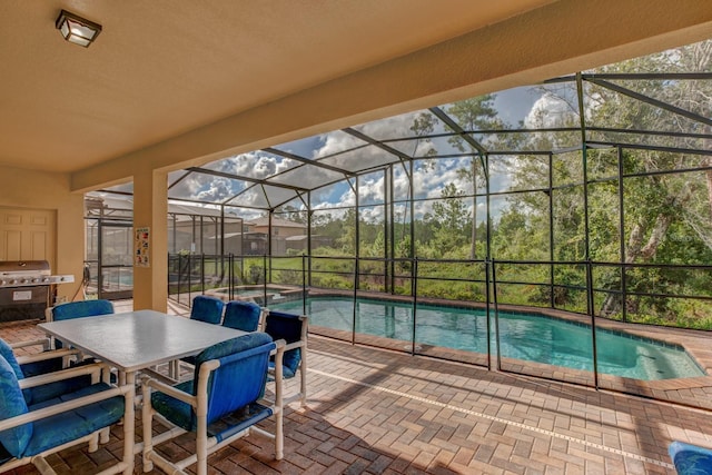 view of pool featuring glass enclosure and a patio