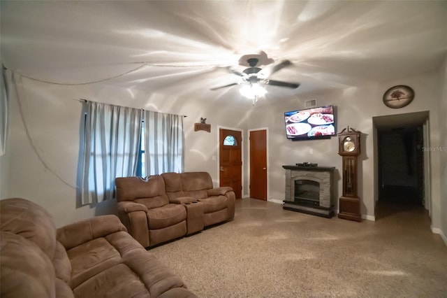 living room featuring ceiling fan and a stone fireplace