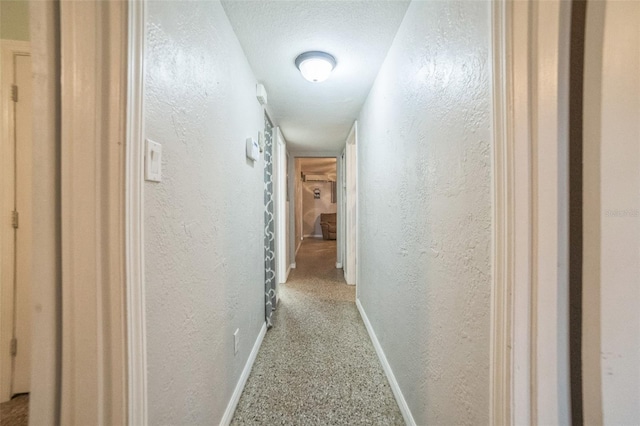 hallway with a textured ceiling