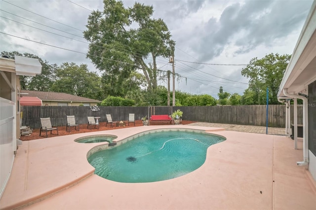 view of pool with a patio area and an in ground hot tub