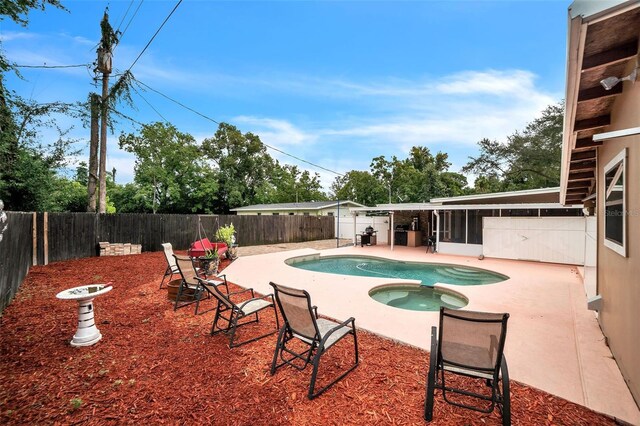 view of pool with a patio area and an in ground hot tub