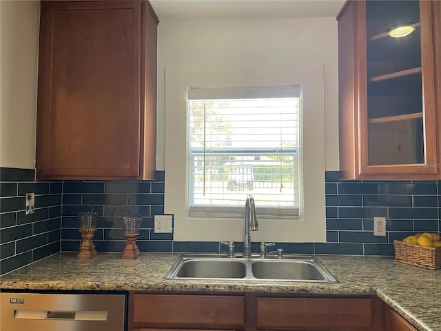 kitchen featuring stainless steel dishwasher, backsplash, and sink