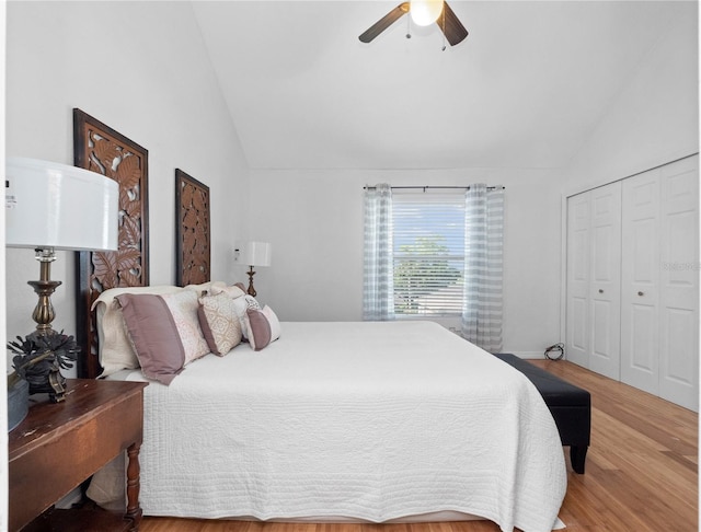 bedroom with ceiling fan, a closet, light wood-type flooring, and vaulted ceiling