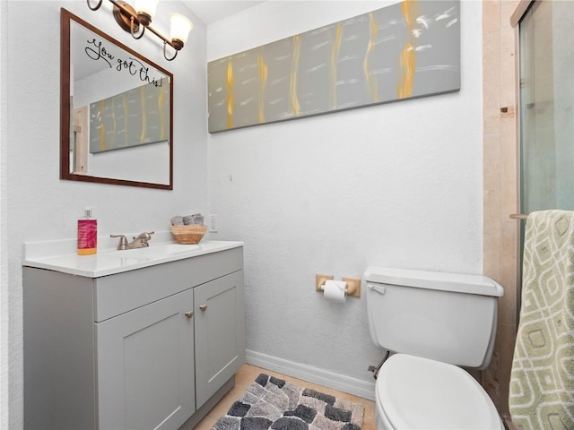 bathroom featuring an enclosed shower, toilet, and vanity