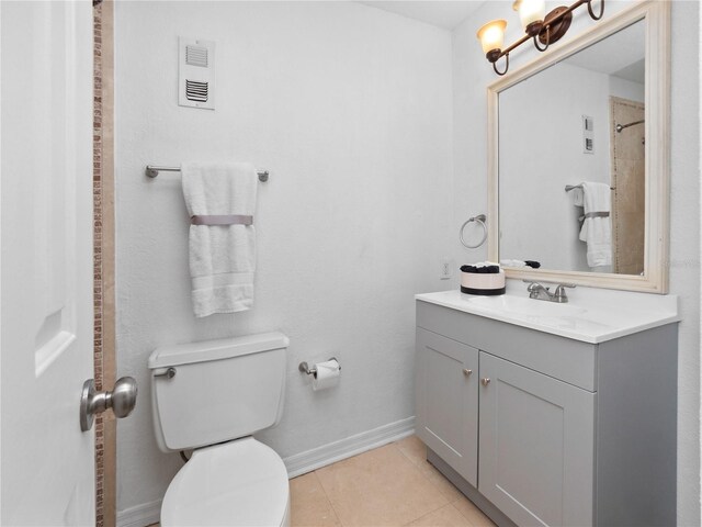 bathroom featuring vanity, toilet, walk in shower, and tile patterned flooring