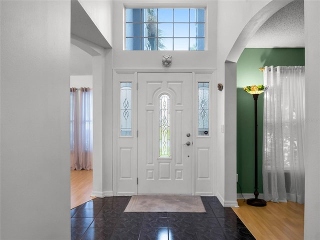 entrance foyer featuring a textured ceiling, plenty of natural light, and dark hardwood / wood-style flooring