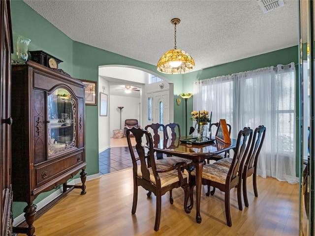 dining space featuring a textured ceiling, ceiling fan, and hardwood / wood-style flooring