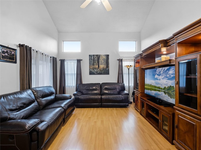 living room with light hardwood / wood-style floors, ceiling fan, and high vaulted ceiling