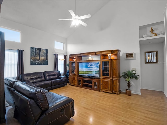 living room with hardwood / wood-style flooring, ceiling fan, and high vaulted ceiling