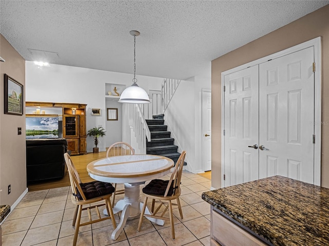 dining space featuring a textured ceiling and light tile patterned flooring