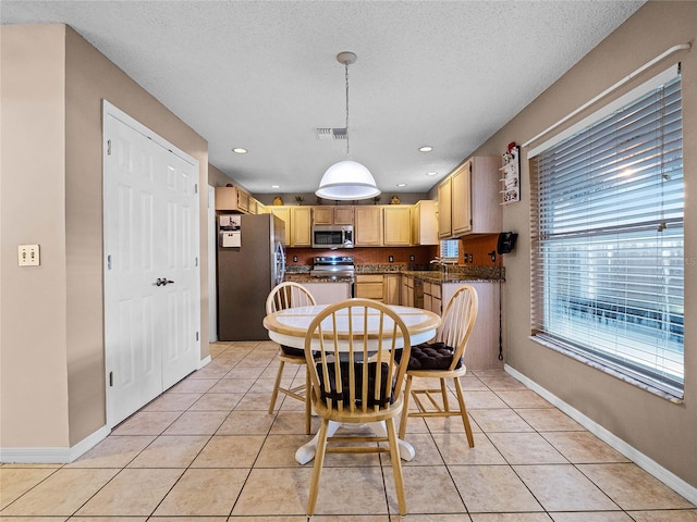 tiled dining room with a textured ceiling and sink