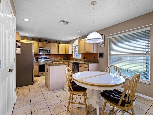 dining space with a textured ceiling, sink, and light tile patterned floors