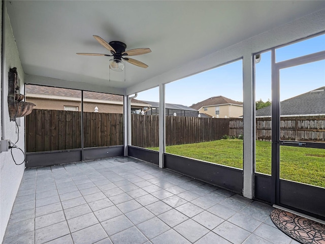 unfurnished sunroom featuring ceiling fan