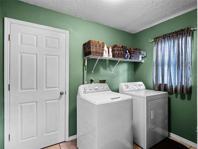 washroom with tile patterned floors, a textured ceiling, and separate washer and dryer