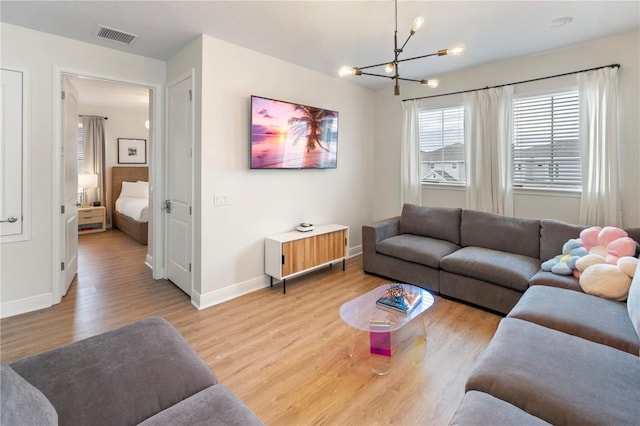 living room with light hardwood / wood-style flooring and a notable chandelier