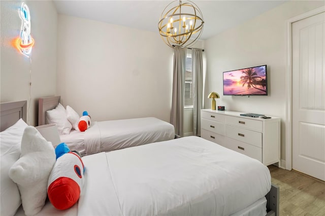 bedroom featuring light wood-type flooring and a chandelier