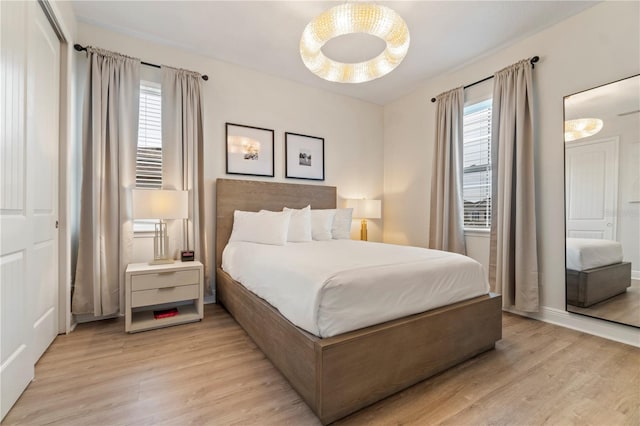 bedroom with multiple windows, ceiling fan, and light hardwood / wood-style flooring