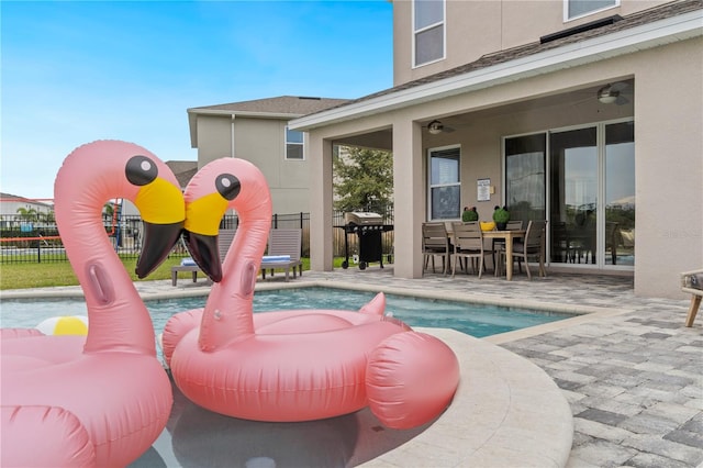 view of pool featuring ceiling fan, a grill, and a patio area