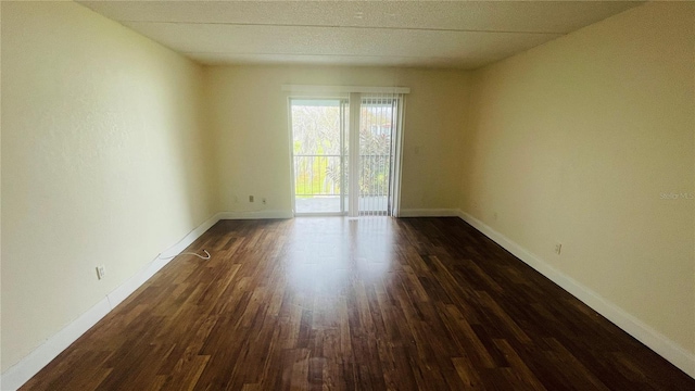 unfurnished room with dark hardwood / wood-style flooring