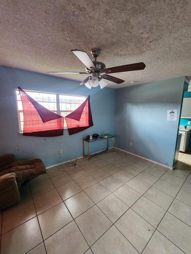 unfurnished room featuring tile patterned flooring, ceiling fan, and a textured ceiling