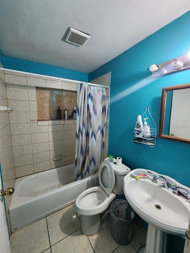 full bathroom with tile patterned flooring, shower / bath combo, toilet, sink, and a textured ceiling