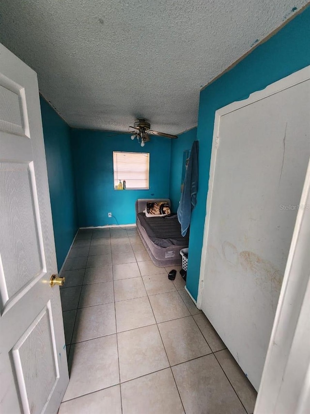 bathroom featuring ceiling fan, a textured ceiling, and tile patterned flooring