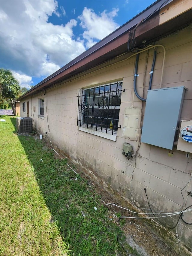 view of property exterior featuring central AC and a yard