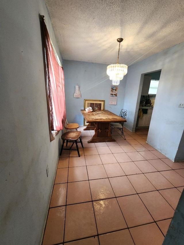 unfurnished dining area with an inviting chandelier, a textured ceiling, and light tile patterned flooring