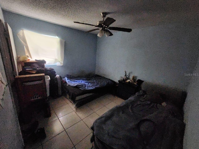 tiled bedroom featuring a textured ceiling and ceiling fan