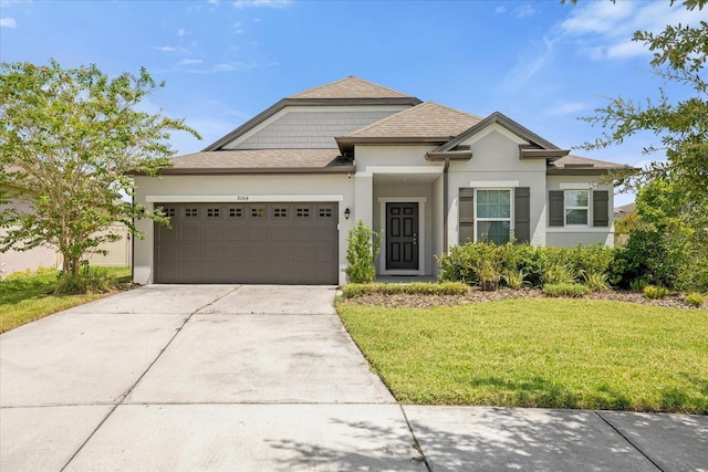 view of front of house with stucco siding, a front lawn, roof with shingles, concrete driveway, and an attached garage