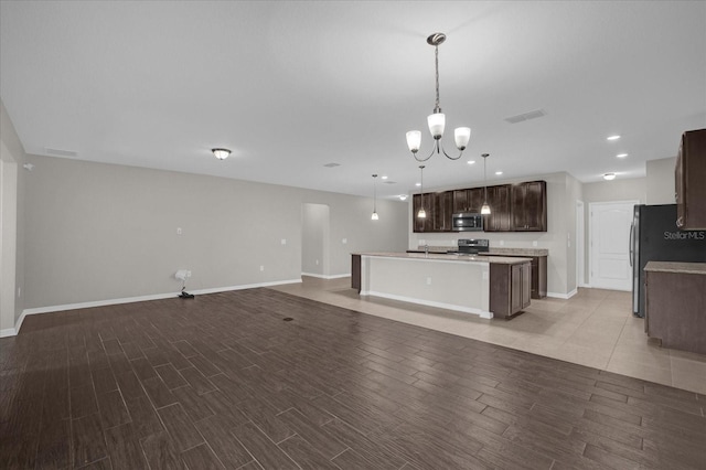 8064 Olive Brook Dr, Wesley Chapel, FL 33545 - kitchen featuring visible vents, open floor plan, light wood-style floors, appliances with stainless steel finishes, and dark brown cabinets