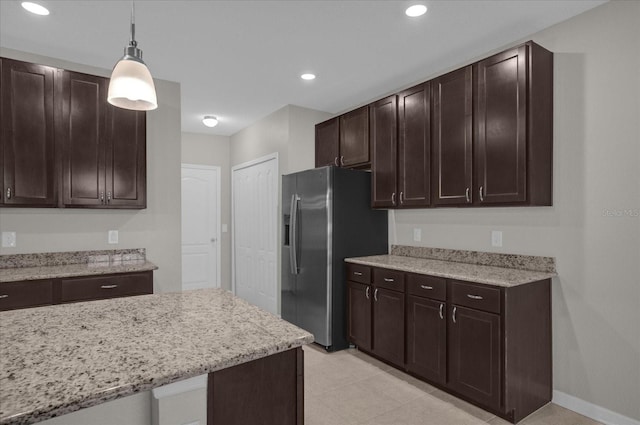 8064 Olive Brook Dr, Wesley Chapel, FL 33545 - kitchen with light stone counters, recessed lighting, dark brown cabinets, pendant lighting, and stainless steel fridge
