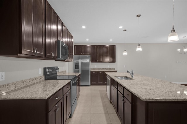 8064 Olive Brook Dr, Wesley Chapel, FL 33545 - kitchen with an island with sink, a sink, decorative light fixtures, appliances with stainless steel finishes, and dark brown cabinets