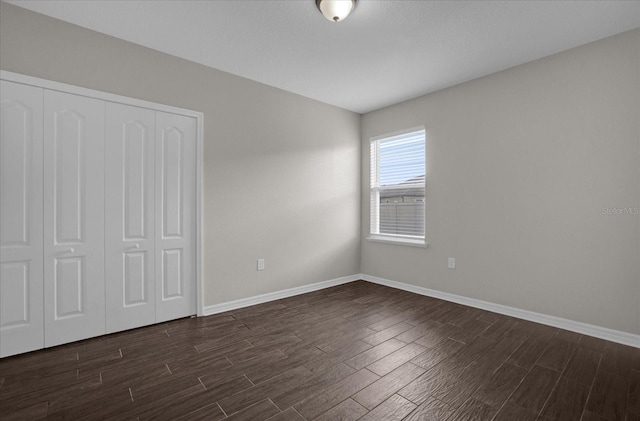 8064 Olive Brook Dr, Wesley Chapel, FL 33545 - unfurnished bedroom featuring a closet, baseboards, and dark wood-style floors