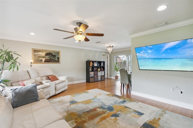 living room featuring light hardwood / wood-style flooring, ceiling fan, and ornamental molding