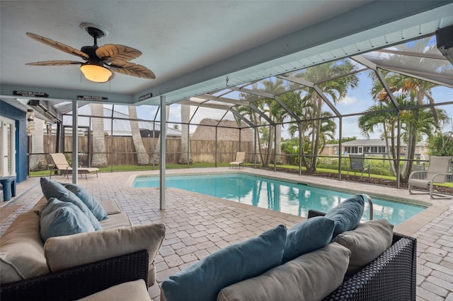 view of swimming pool with an outdoor hangout area, glass enclosure, a patio area, and ceiling fan